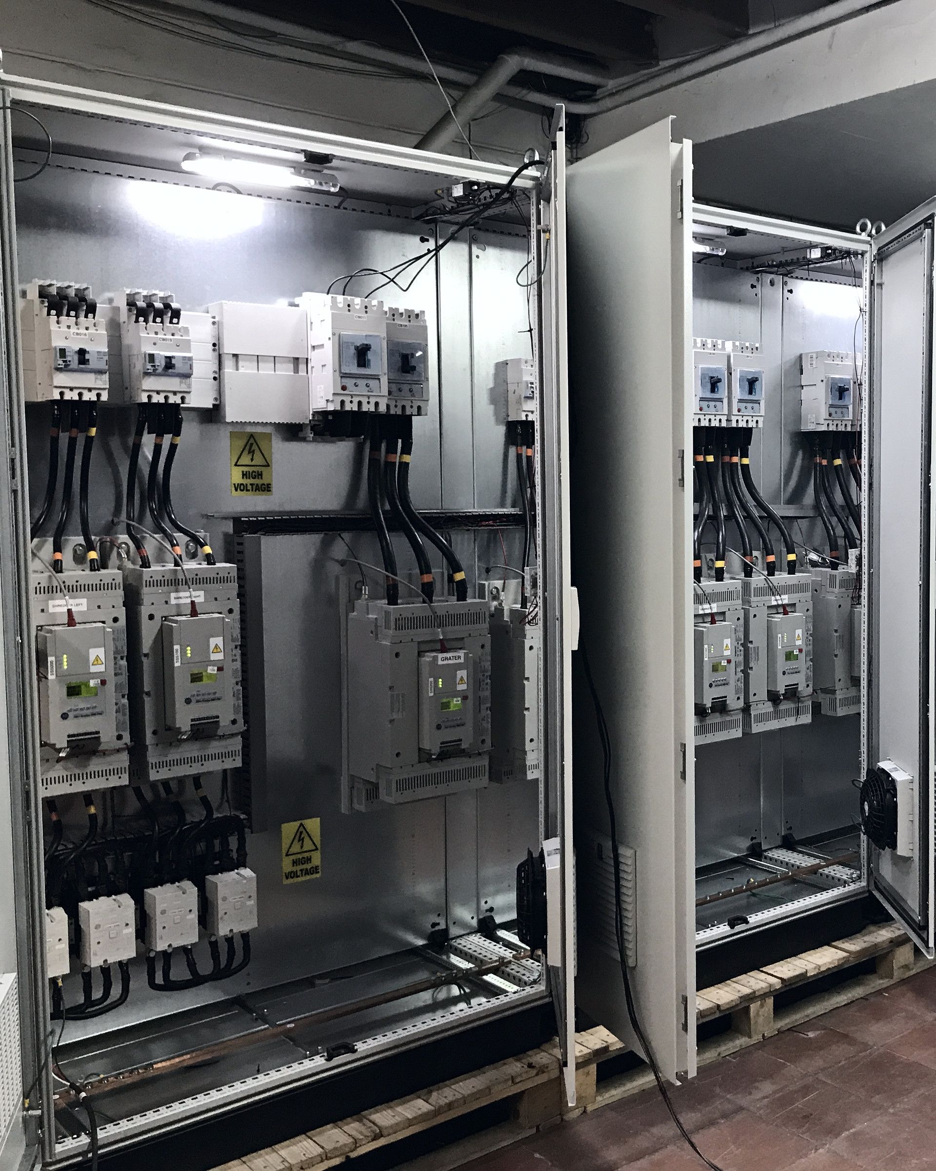 Open multi-bay control panels with contactors, drives and a PLC rack