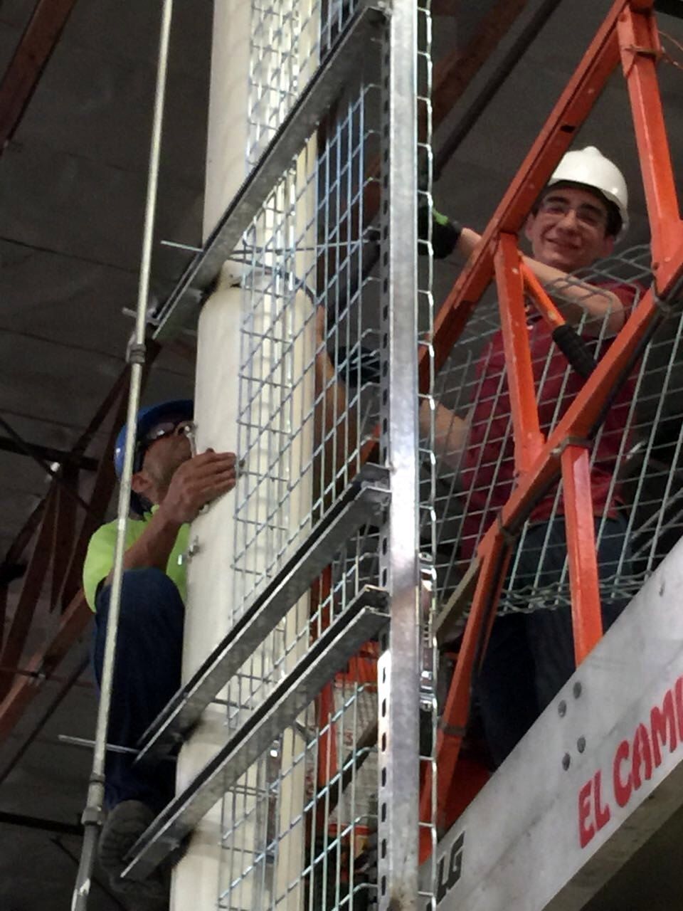 Technicians on a scissor lift installing a cable-tray riser