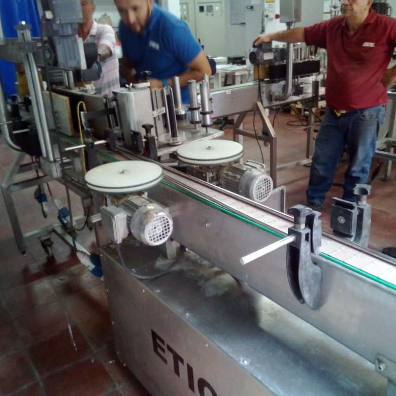 Técnicos de DDI junto a una línea de etiquetado en el taller.