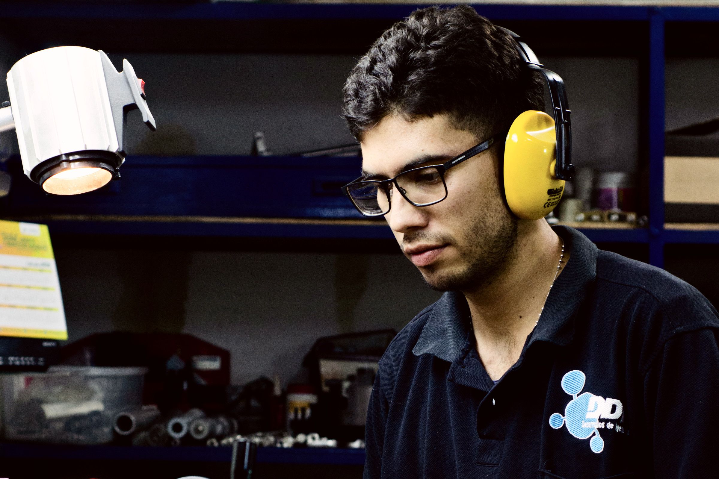 Technician with ear defenders operating a machine tool in the DDI workshop